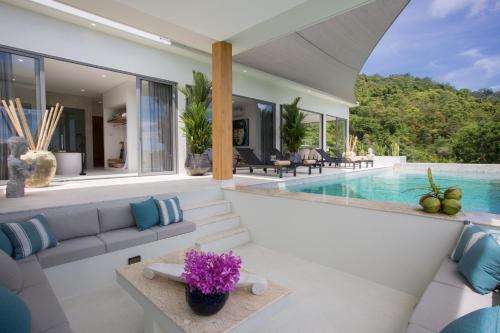 a villa with a swimming pool and a living room at Zog Villas in Koh Samui 
