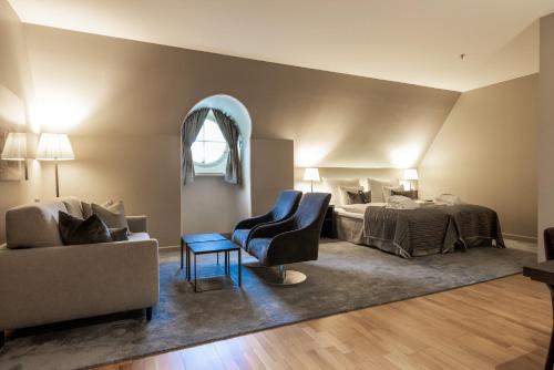 a bedroom with a bed and a couch and a chair at Clarion Hotel Post in Gothenburg