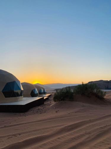 two domes in the desert with the sunset in the background at Syndebad desert camp in Wadi Rum