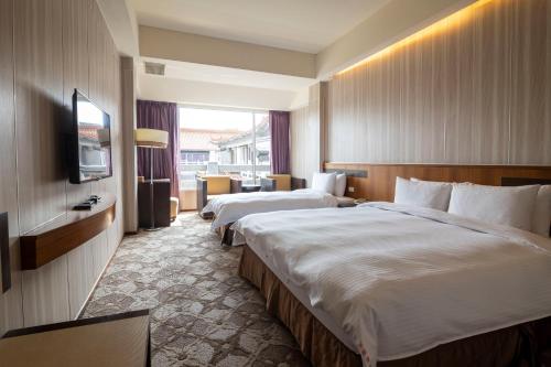 ein Hotelzimmer mit 2 Betten und einem TV in der Unterkunft 水漾月明度假文旅 in Touwu