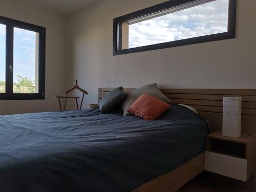 - une chambre avec un lit bleu et 2 fenêtres dans l'établissement La Pagode, à Toulouges