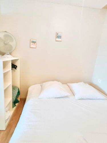 - un lit blanc avec deux oreillers dans l'établissement Heol * plage à 100m*, à Larmor-Plage