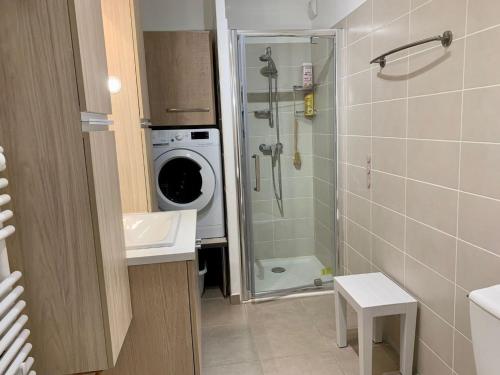 une salle de bain avec une machine à laver et un lave-linge dans l'établissement Splendide T3 avec Terrasse et Box Privé à 2 Pas de l'Étang de Thau - FR-1-604-41, à Mèze