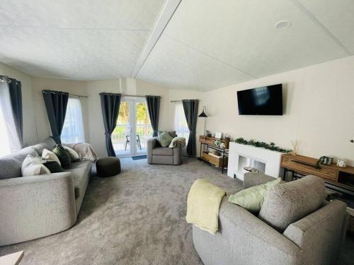 a living room with two couches and a tv at Pine Lodge with Hot Tub in York