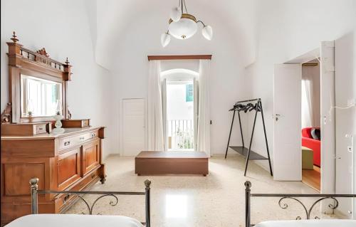 Habitación blanca con tocador y espejo. en Dimora Luxury con Terrazza - Centro Storico Ostuni, en Ostuni