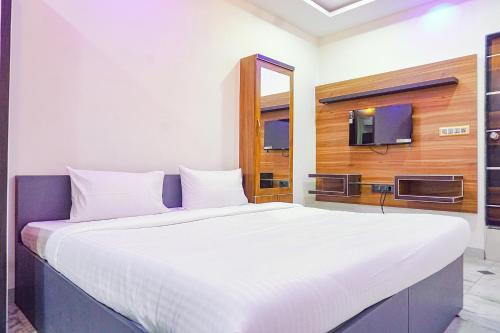 a large white bed in a room with a tv at FabHotel Classic Square in Pune