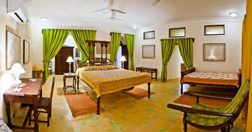 a bedroom with two beds and a table and chairs at Neemrana's - Tijara Fort Palace in Alwar