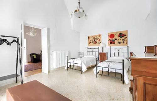 a white room with two beds and a table at Ostuni 10min dal Mare - Dimora Luxury con Terrazza in Ostuni