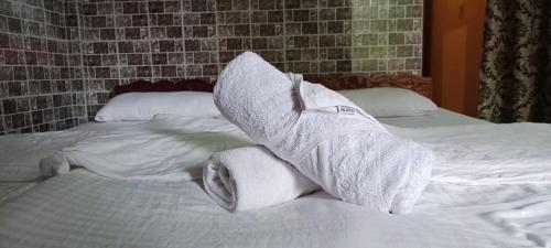 a pile of rolled towels on a bed at selfia guest house in Majorda