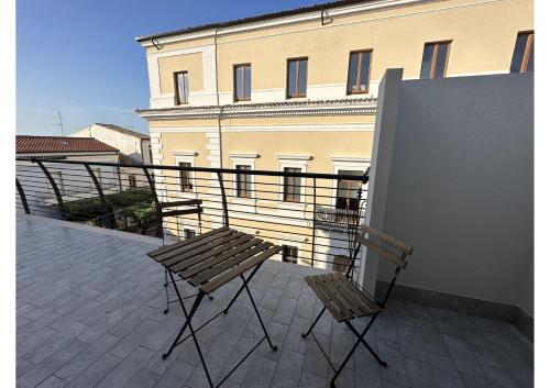 d'un balcon avec une table en bois et deux chaises. dans l'établissement Villino Tokupellon Apartments, à Cupello