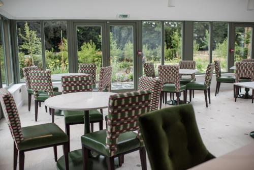 a room with tables and chairs and windows at Dewars Restaurant and Rooms in Malton
