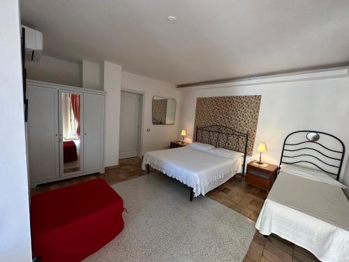 a bedroom with a white bed and a red chair at Villino Tokupellon Apartments in Cupello