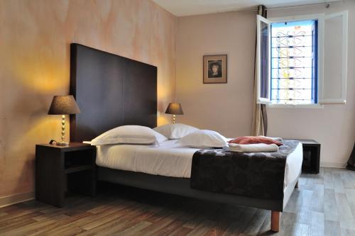sypialnia z dużym łóżkiem i oknem w obiekcie HOTEL RESTAURANT CORTIE w mieście Thuir