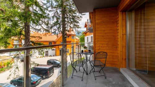 a balcony with a table and chairs and a street at Apartamenty Good Time - Stone Hill IV in Szklarska Poręba