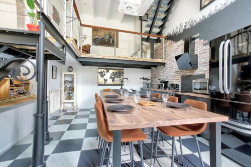 une cuisine avec une table et des chaises dans une pièce dans l'établissement Loft Arvor - Charmant loft avec jardin, à Dinan