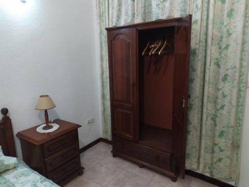 Cozy Room in Plateau في برايا: غرفة نوم مع خزانة خشبية كبيرة بجوار سرير