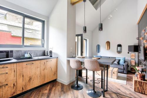 une cuisine avec une table et des chaises dans une pièce dans l'établissement Cosy Lodge - Charmant lodge en plein cœur de Dinan, à Dinan