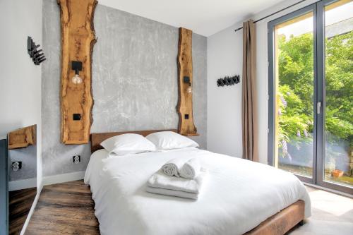 - une chambre avec un lit blanc et des serviettes dans l'établissement Cosy Lodge - Charmant lodge en plein cœur de Dinan, à Dinan