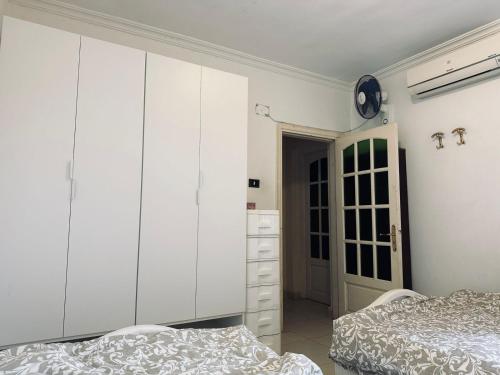 a bedroom with two beds and a large white cabinet at Spacious Beach Vacation House in El Alamein