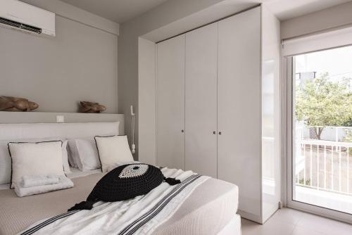 a bedroom with a bed and a large window at Bliss Living in Vouliagmeni