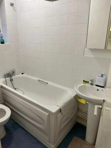 ein Badezimmer mit einer Badewanne, einem Waschbecken und einem WC in der Unterkunft Small Studio apartment - quick access to all of london in London