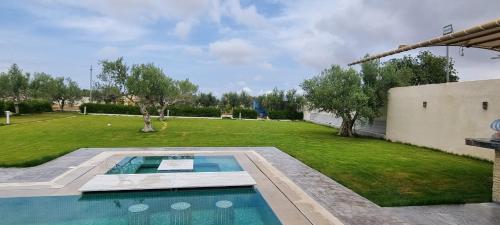 a swimming pool in the middle of a yard at Maison dolce vita in Ţūzah