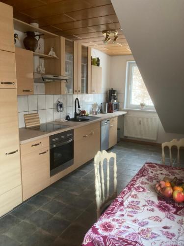 a kitchen with a table with a bowl of fruit on it at Immensee in Ronshausen