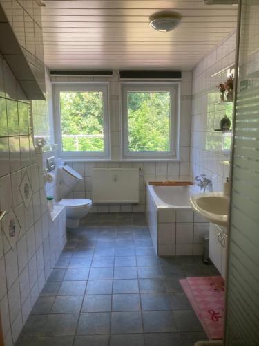 baño con 2 lavabos, bañera y 2 aseos en Immensee en Ronshausen