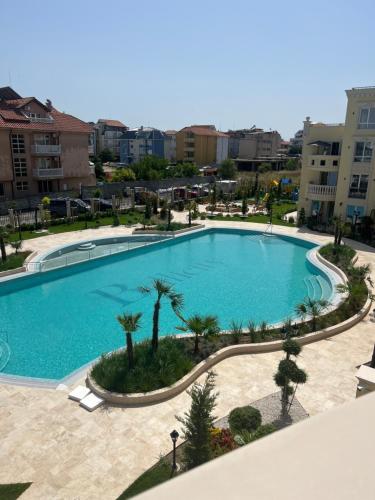an overhead view of a large swimming pool with palm trees at Sunny apartment in Bellicity complex in Ravda