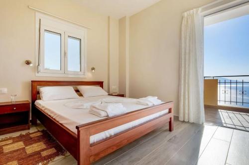 a bedroom with a bed and a large window at Kleio Studios in Ravdhoúkha