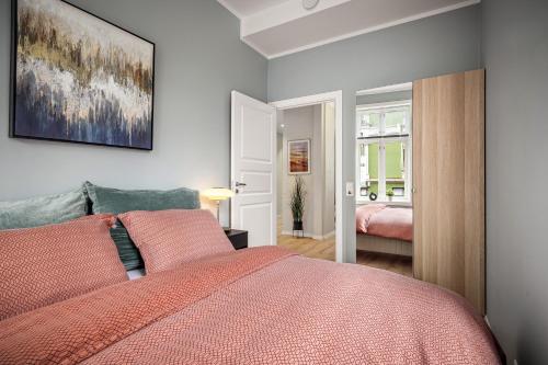 um quarto com uma cama com um edredão vermelho em Corner Apartments em Bergen
