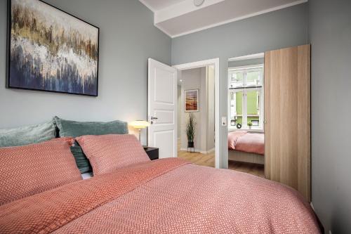 a bedroom with a bed with a red comforter at Corner Apartments in Bergen