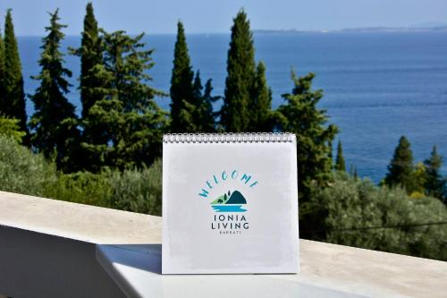 a sign on a railing with a view of the ocean at Ionia Living in Barbati