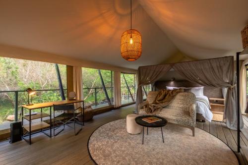 a bedroom with a bed and a table in a room at Mbizane Escarpment Retreat in Schoemanskloof