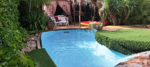 una piscina en un patio con arbustos en Viviendas Uso Turisitico, Al BUHAR, en Torrejón del Rey