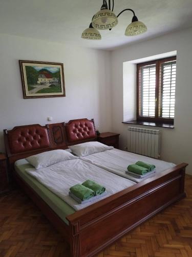 a bedroom with a large bed with two green pillows at Apartma Logar in Kobarid