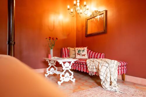 a living room with a red couch and a table at ELIVAAS 5 BHK with Pvt Pool, Entertainment Room & Glass House - Bludoor in Marmagao