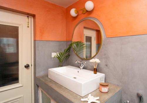 a bathroom with a white sink and a mirror at ELIVAAS 5 BHK with Pvt Pool, Entertainment Room & Glass House - Bludoor in Marmagao