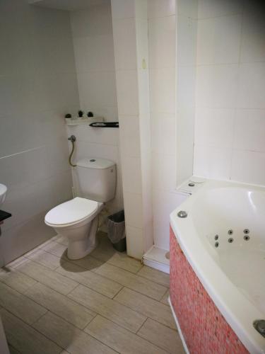 a bathroom with a toilet and a bath tub at Q Village - Poleg Beach in Netanya