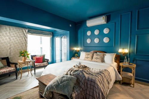 een slaapkamer met blauwe muren en een groot bed bij Elivaas Bludoor Luxe 5BHK Villa with Pvt Pool, Assagao in Marmagao