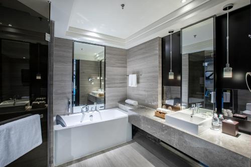 a bathroom with two sinks and two mirrors at Renaissance Guiyang Hotel in Guiyang
