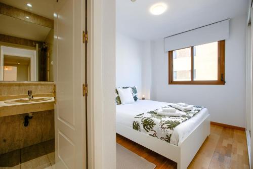馬德里的住宿－Charming Madrid Airport，一间卧室配有床、水槽和镜子
