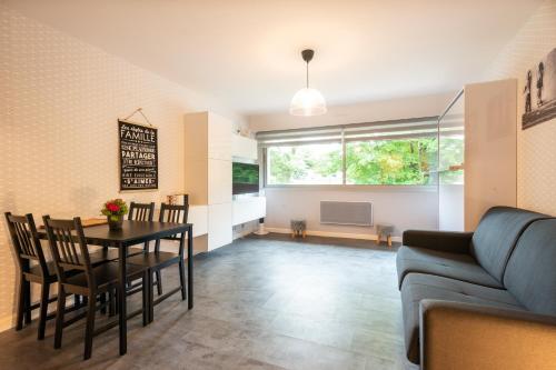 un salon avec une table, des chaises et un canapé dans l'établissement Le Hardelot - Studio à 2 km de la plage, à Neufchâtel-Hardelot