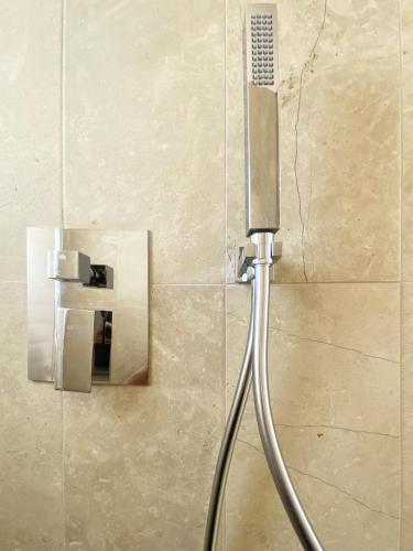 a shower head in a bathroom with a wall at La casa di Irene - Suites con vista in Ragusa