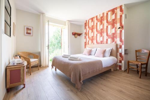 una camera da letto con un grande letto con cuscini rosa di LE CLOS VERSAILLES BEYNAC a Beynac-et-Cazenac