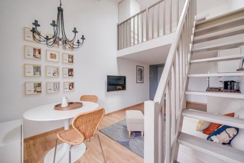 une pièce avec une table, des chaises et un escalier dans l'établissement Les Toits - Location Moyenne Durée - Centre, à Bordeaux