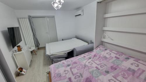 a small room with two beds and a pink blanket at SeaNest Mangalia in Mangalia