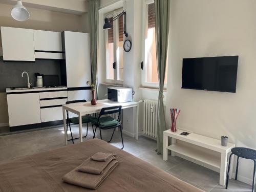 帕爾馬的住宿－VIOLETTA DI PARMA，配有床和桌子的房间以及厨房