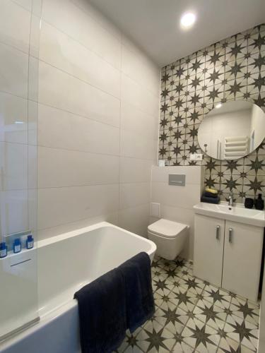 baño blanco con bañera y aseo en Apartments PSD - Wojska Polskiego 6, en Słupsk