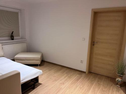 a bedroom with a bed and a wooden door at Dom Melissa v malebnej obci Banka in Piešťany